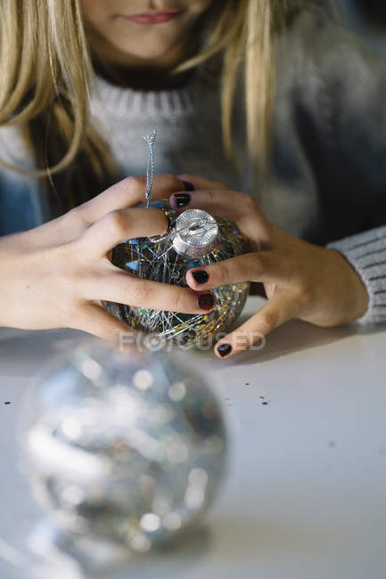 Partial view of little girl hands with Christmas balls — Stock Photo