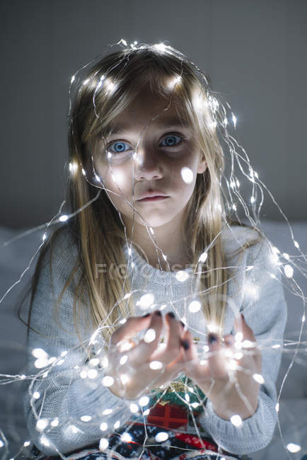 Belle blonde preteen fille portant illuminé guirlande de Noël avec des ampoules lumineuses — Photo de stock