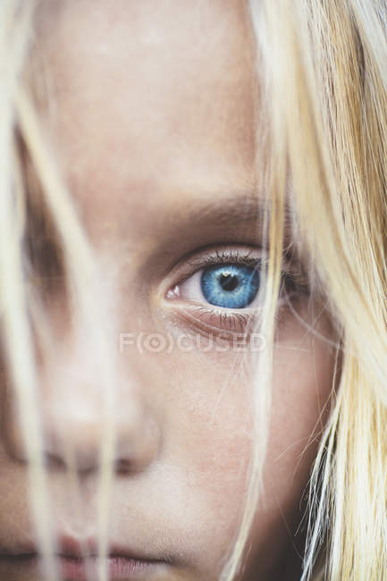 Close up shot of beautiful blonde preteen girl, partial view of blue eye — Stock Photo