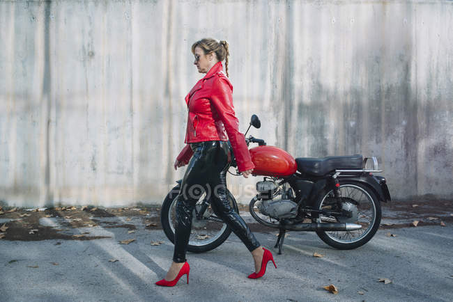 Mulher de moto caminhar ao lado da motocicleta — Fotografia de Stock