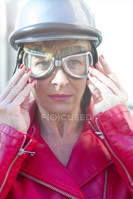 Woman putting off Helmet sitting on a bike — Stock Photo