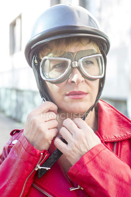 Mulher adiando capacete sentado em uma bicicleta — Fotografia de Stock