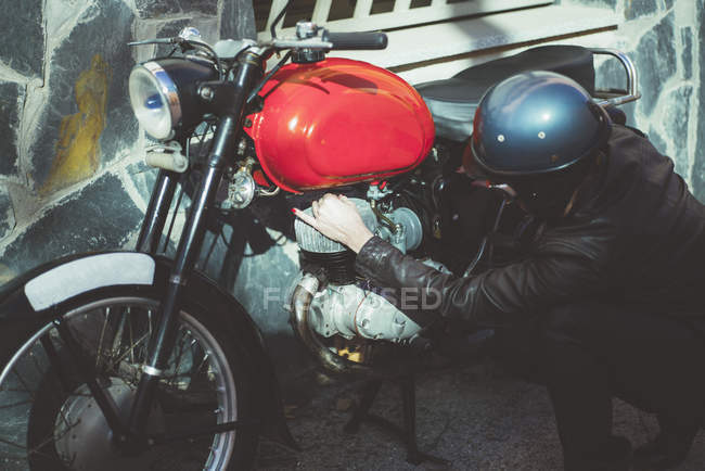 Motociclista donna organizza moto danneggiate — Foto stock