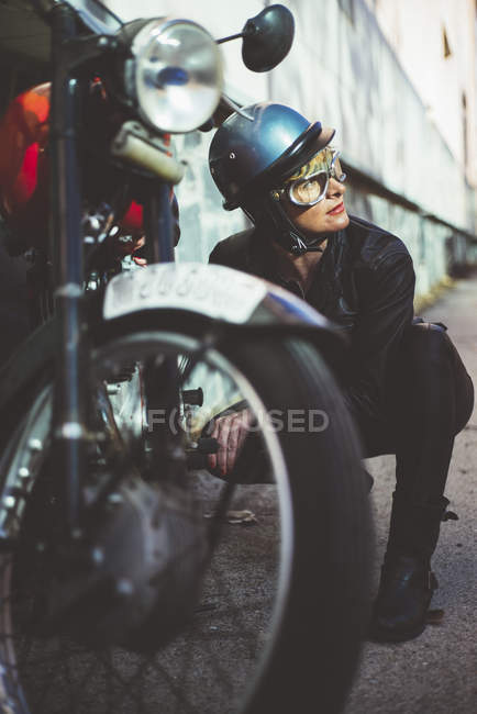 Мотоциклистка устраивает поврежденный мотоцикл — стоковое фото