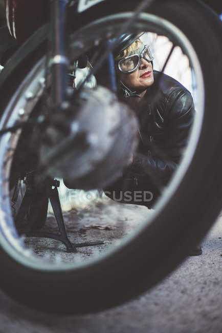 Жінка на мотоциклі влаштовує пошкоджений мотоцикл — стокове фото