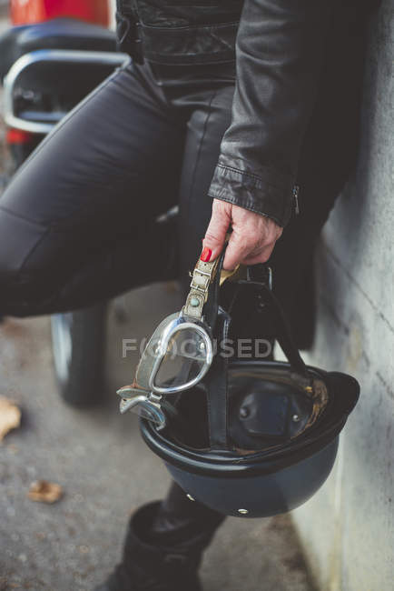 Helmet and goggles in the hand of the motorbike woman — Stock Photo