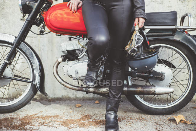 Capacete e óculos na mão da mulher motocicleta — Fotografia de Stock