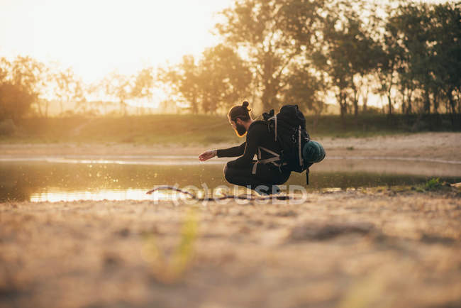 Backpacker am See spielt mit Wasser — Stockfoto