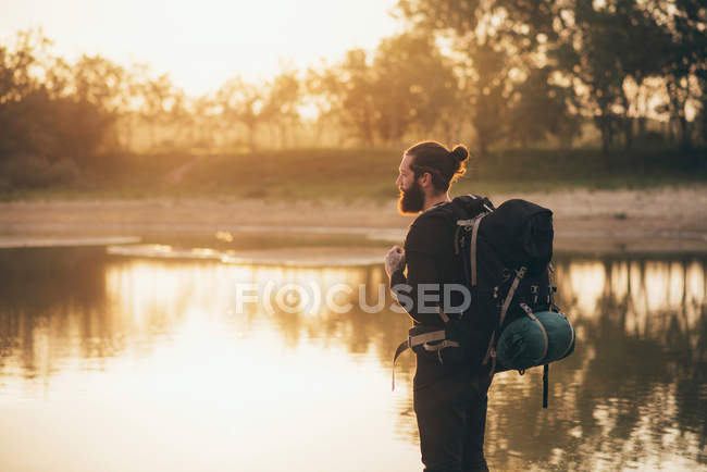 Wanderer blickt bei Sonnenaufgang über den See — Stockfoto