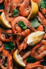 Vue surélevée de tas de crevettes, tranches de citron et feuilles de menthe — Photo de stock