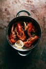 Top view of crayfishes with bay leaf and lemon slices in saucepan — Stock Photo