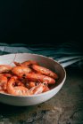 Closeup view of pile of shrimps on plate and kitchen towel on table — Stock Photo