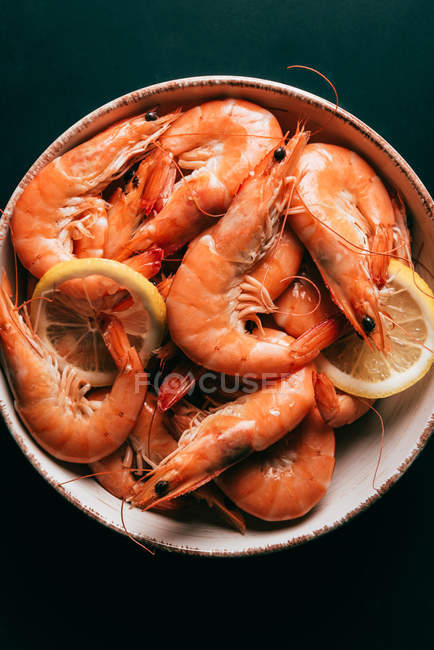 Vue de dessus des tranches de citron et des crevettes sur l'assiette — Photo de stock