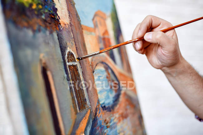 Male artist painting his picture — Stock Photo