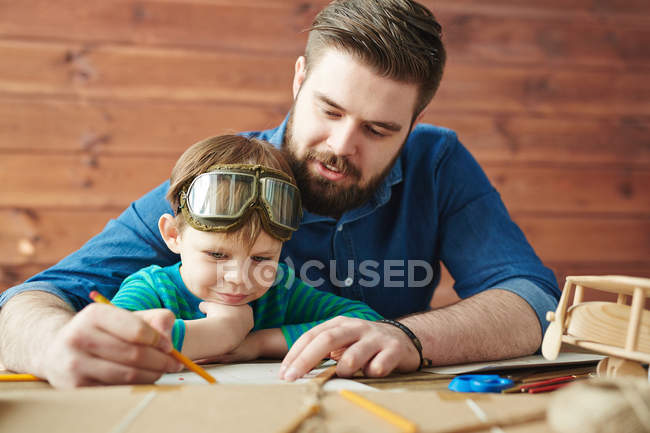 Mann mit Sohn zeichnet Skizze von Spielzeug — Stockfoto