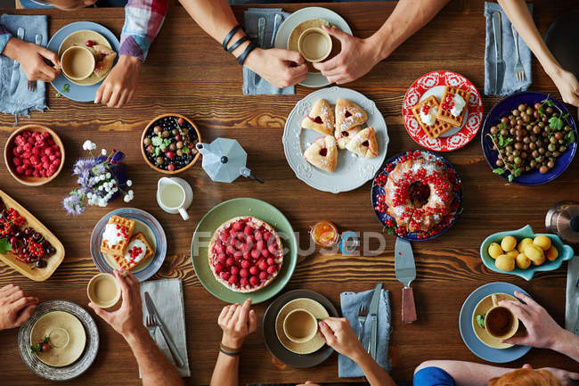 Mains d'amis sur la table de fête servie — Photo de stock