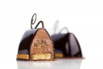 Pasteles de chocolate con relleno de crema sobre fondo blanco - foto de stock