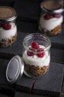 Yogurt and granola parfait in jars on table — Stock Photo