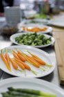 Baby carrots and vegetable garnishes on table — Stock Photo
