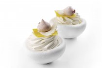Postre de merengue con crema sobre fondo blanco - foto de stock