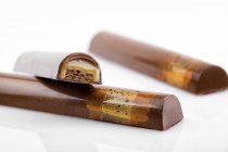 Bonbons au chocolat avec garniture au caramel sur fond blanc — Photo de stock