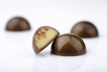 Dulces de chocolate con relleno de caramelo sobre fondo blanco - foto de stock