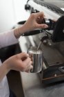 Vue rapprochée des mains féminines de barista moussant le lait — Photo de stock