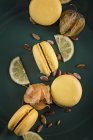 Yellow macarons with lemon slices and physalis fruits — Stock Photo