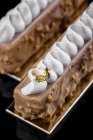 Barras de pastel con glaseado de chocolate y decoración de crema - foto de stock