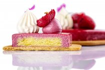 Pasteles con esmalte rosa y frambuesas frescas - foto de stock