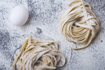 Hausgemachte Pasta auf Küchentisch mit Ei — Stockfoto