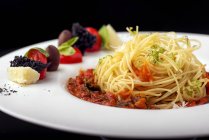 Spaghetti dish with tomato sauce and vegetable garnish — Stock Photo