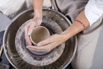 Visão de close-up de mãos de oleiro feminino fazendo pote — Fotografia de Stock