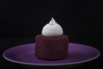 Cake with cream decoration on purple plate — Stock Photo