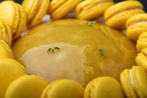 Close-up of cake with yellow marmalade and macarons decoration — Stock Photo
