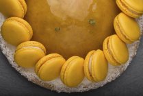 Primer plano del pastel con mermelada amarilla y decoración de macarrones - foto de stock