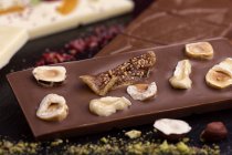 Крупный план шоколадной плитки с орехами и сушеным инжиром — стоковое фото