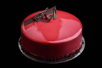 Cake with red glaze and chocolate music key decoration — Stock Photo