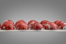 Chocolate candies with red marble glaze — Stock Photo