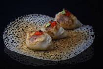 Fried dumplings on rice paper serviette with caviar decoration — Stock Photo