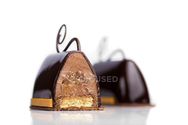 Pasteles de chocolate con relleno de crema sobre fondo blanco - foto de stock