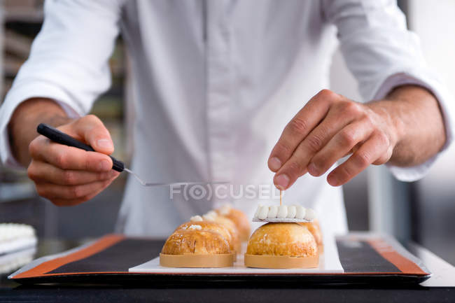 Primer plano de chef masculino decoración de pasteles - foto de stock