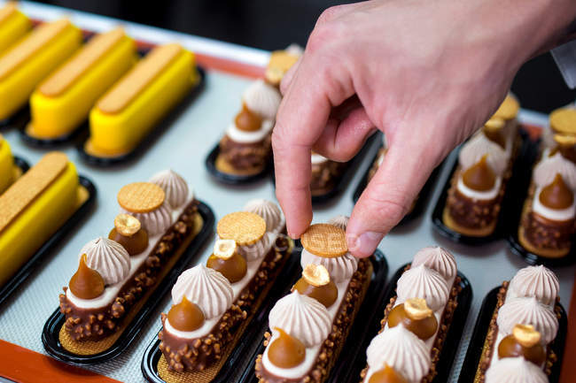 Close-up of male chef decorating eclairs — Stock Photo