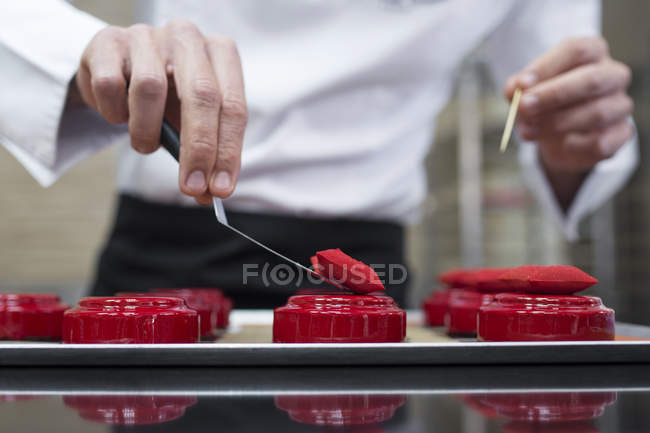 Nahaufnahme des Chefs beim Dekorieren von Kuchen mit essbaren Kissen — Stockfoto