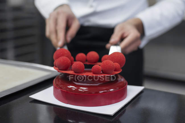 Крупним планом шеф-кухар прикрашає торт з марципаном — стокове фото