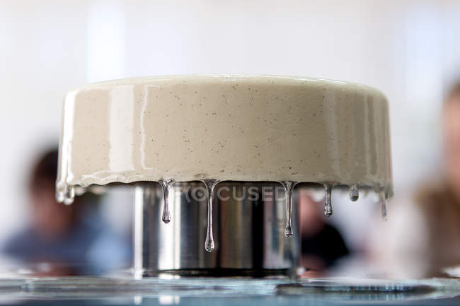 Pastel con esmalte de goteo presentado en el stand - foto de stock
