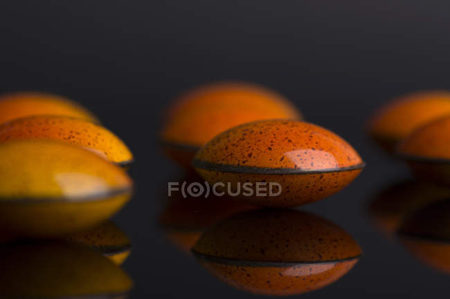 Doces de chocolate com esmalte laranja — Fotografia de Stock