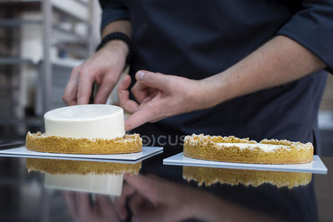 Vista ravvicinata del pasticciere che prepara la torta — Foto stock