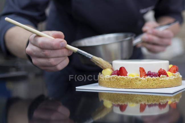 Close-up view of confectioner decorating cake — Stock Photo
