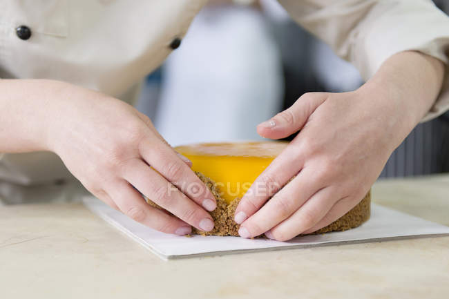 Vista ravvicinata delle mani del pasticcere che fanno la torta — Foto stock